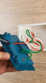 hand-of-an-electrician-is-using-a-screwdriver-to-attach-the-wires-to-the-socket-with-a-plastic-box-on_t20_mlV713